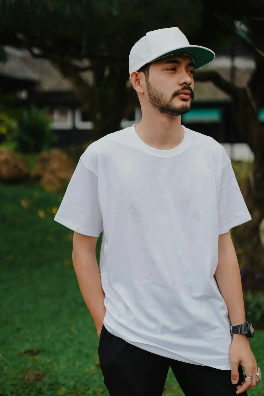 Man in a white oversized t-shirt and cap